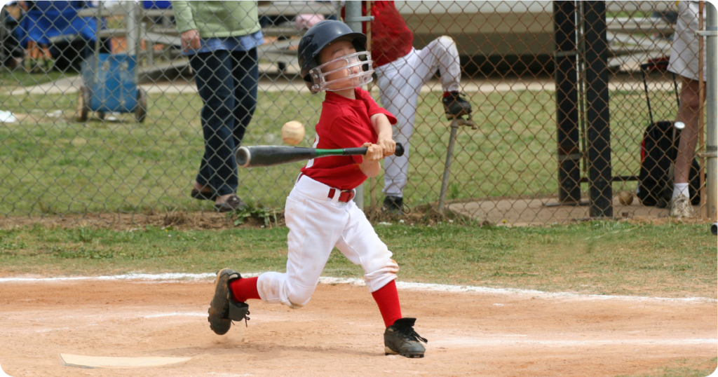 child swinging a baseball bat